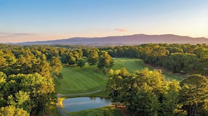 A golf course with a pond, surrounded by dense trees and distant mountains. - Fire Pit.   Private Golf Course.   Summer Club Pool (Greeneville)