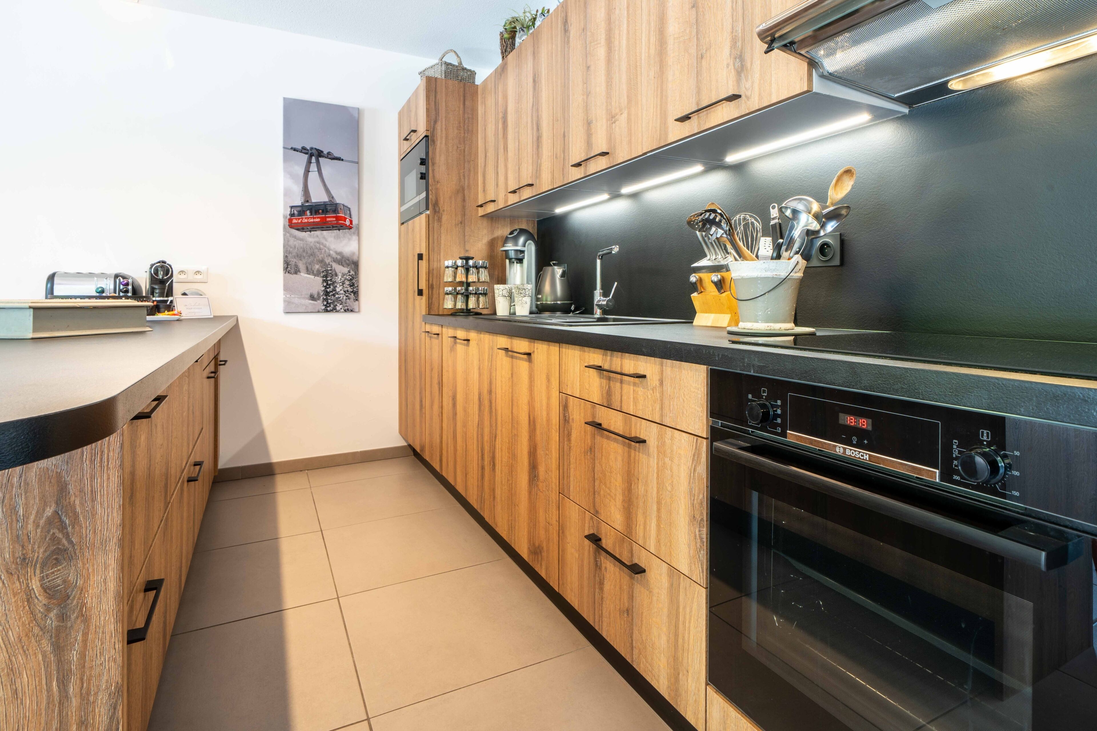 Una cocina moderna con armarios de madera, un horno Bosch y una máquina de café.