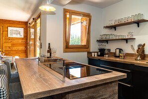 Une cuisine moderne avec des meubles en bois, un îlot central intégré et une fenêtre décorée de motifs en forme de flocon de neige.