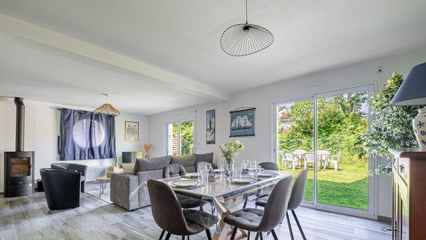 Ein modernes Wohnzimmer mit einem Glastisch, grauen Sofas und einem Kamin.