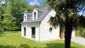 Einbungalow mit Satteldach, einem Rundfenster und einer Tür.