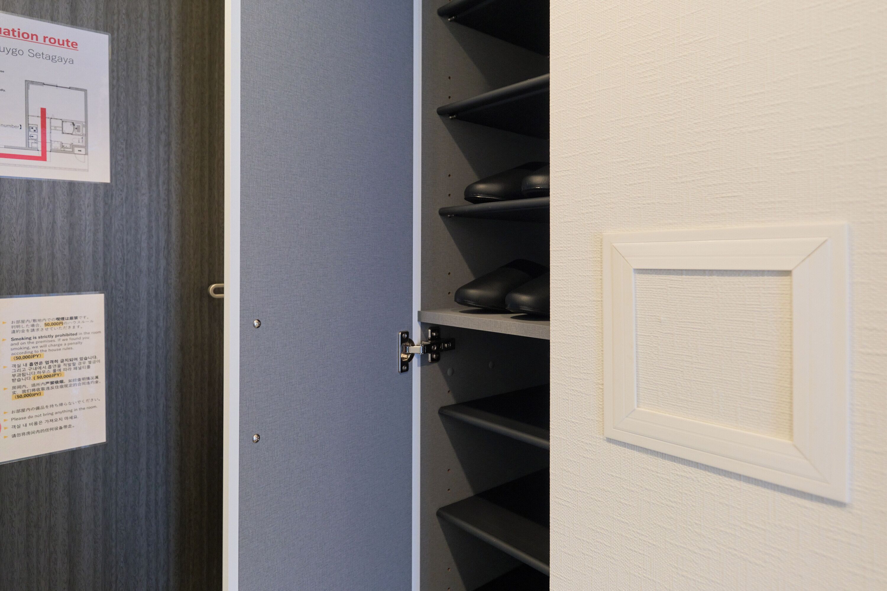 A door with a shoe rack on the right, a map on the left, and a door handle.