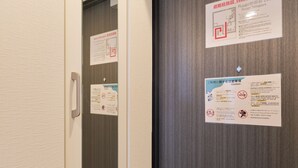 A door with multiple informational signs, including emergency contact numbers and safety instructions.