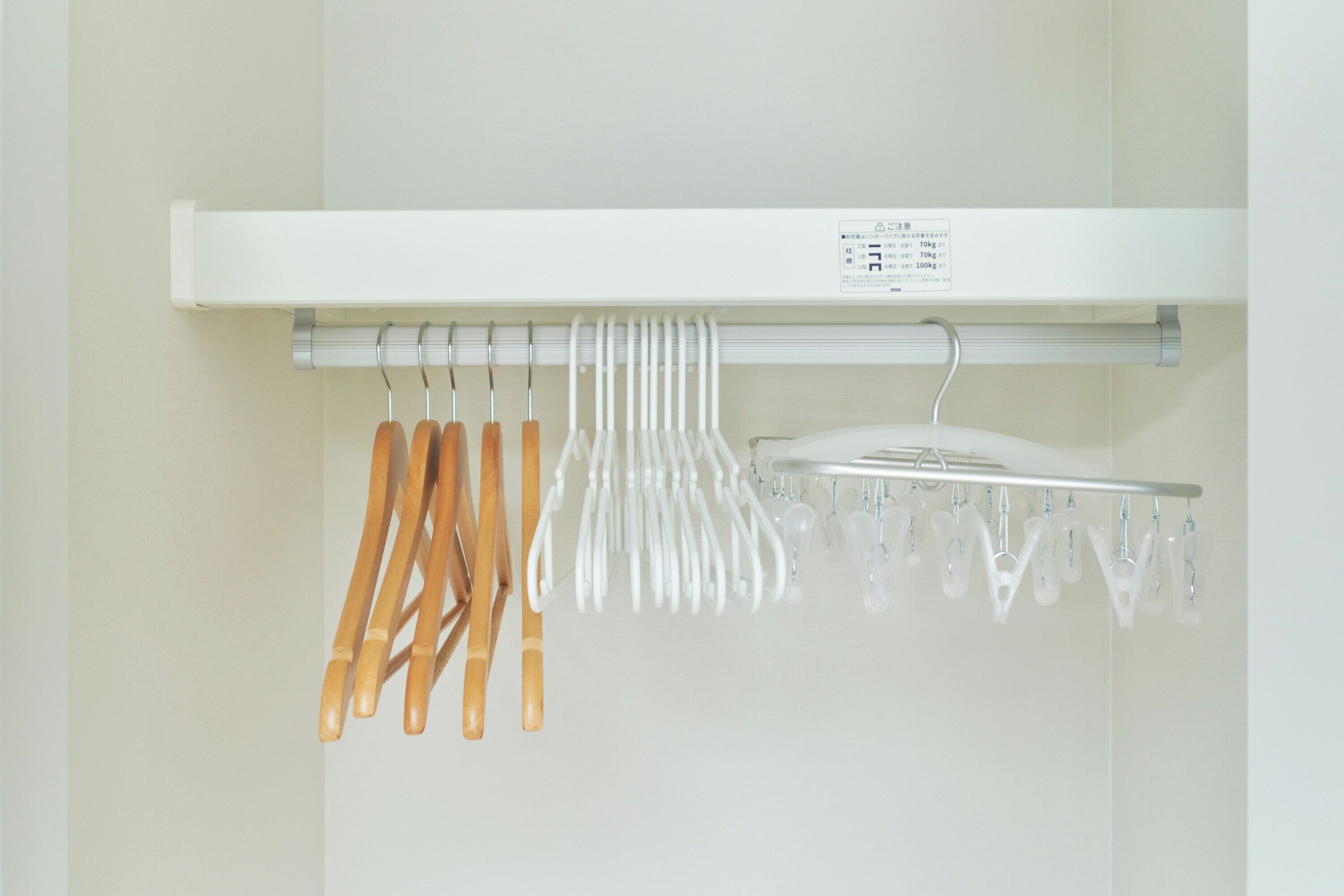 A white shelf with a label, holding various kitchen utensils and a white appliance.
