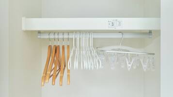 A white shelf with a label, holding various kitchen utensils and a white appliance.