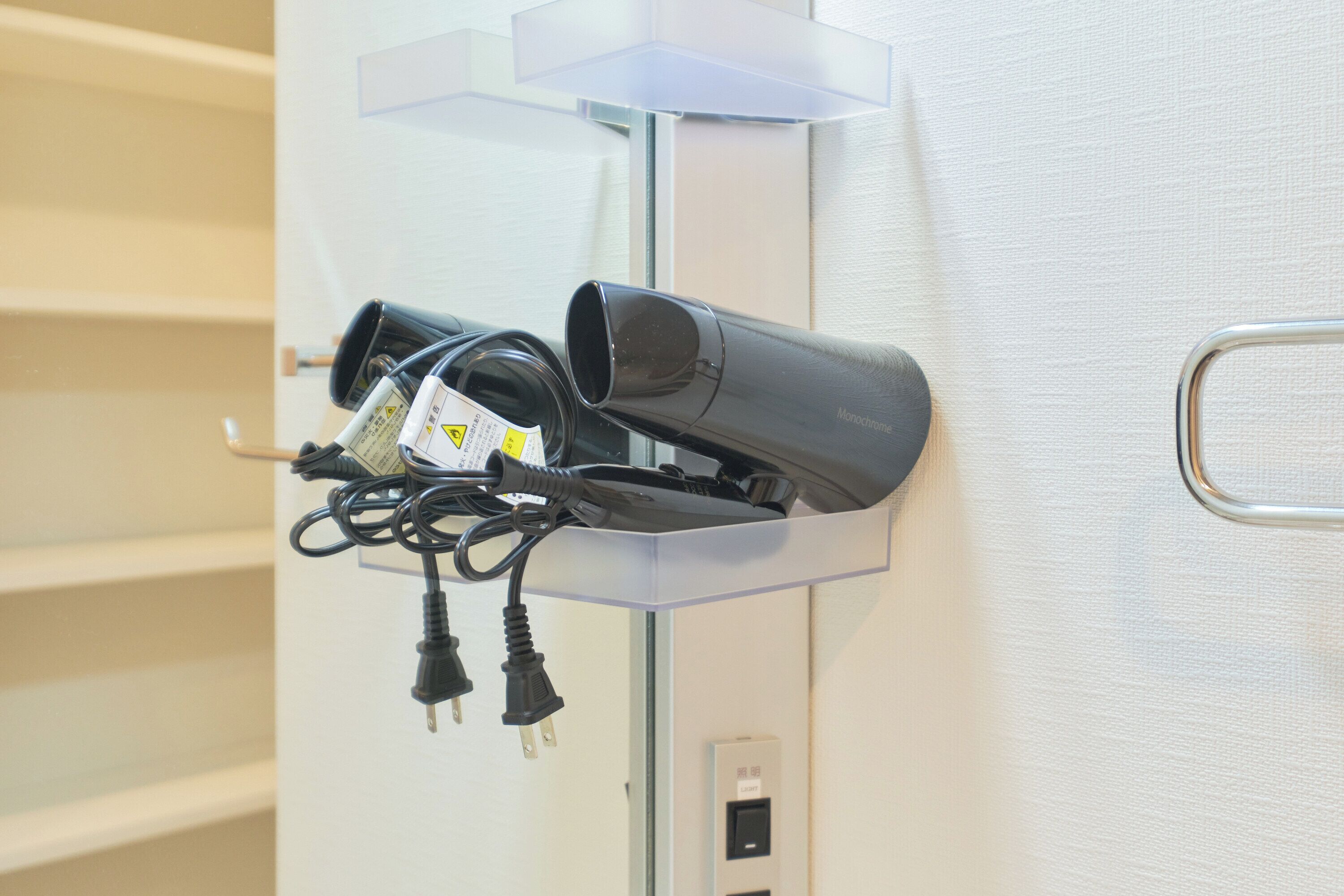 Een wandgeladen oplaadstation met een haardroger en stroomkabels.