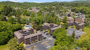Vista aérea de uma área residencial com edifícios de apartamentos, estacionamentos e áreas verdes ao redor.