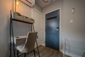 Ein Zimmer mit Schreibtisch, Stuhl und einer blauen Tür mit Schloss.