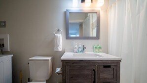 Ein Badezimmer mit Toilette, Waschbecken, Spiegel und Mülleimer.