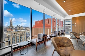 Un intĂ©rieur moderne avec de grandes fenĂȘtres, une vue sur la ville et un mobilier contemporain.