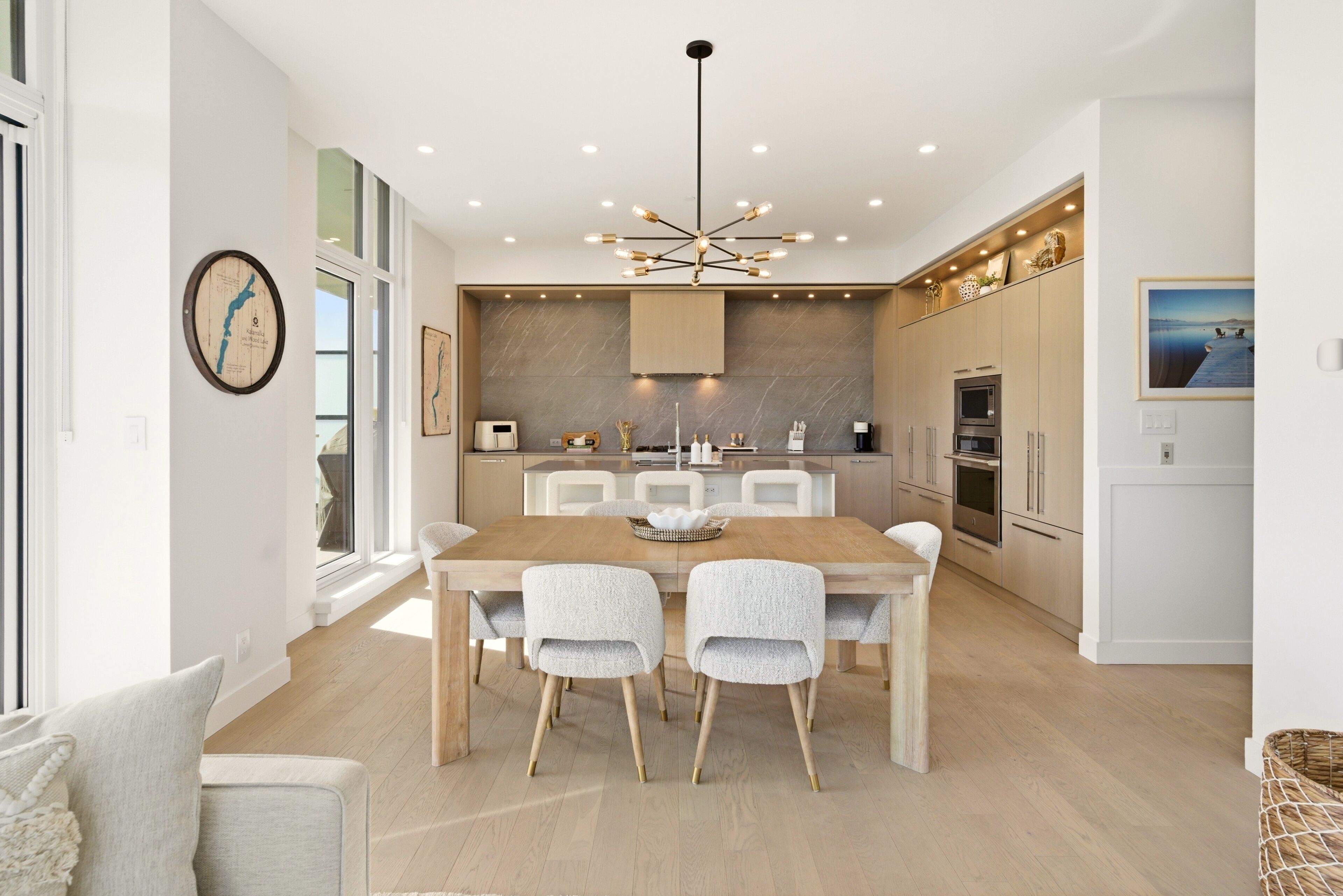 Une cuisine moderne avec une table à manger, des chaises et un lustre.