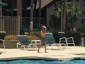 A pool area with lounge chairs and a person walking by. - Available 6/26-7/3/26 only! Sea Pines Villa; 2BR/2BA; Sleeps 6; HHI (Hilton Head Island)