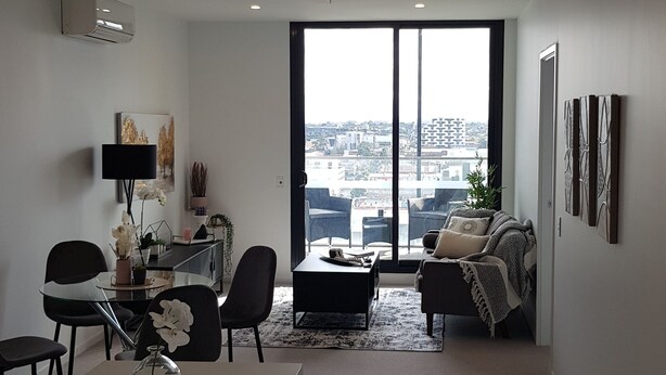 A modern living room with a dining area, large windows, and a city view. - 3 BEDROOM 2 BATHROOMNEW APAQQRTMENT IN FOOTSCRAY 3011 VIC (Footscray)
