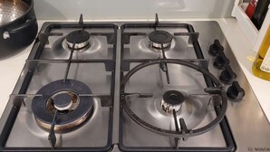A four-burner gas stove with a pot on the left burner. - 3 BEDROOM 2 BATHROOMNEW APAQQRTMENT IN FOOTSCRAY 3011 VIC (Footscray)