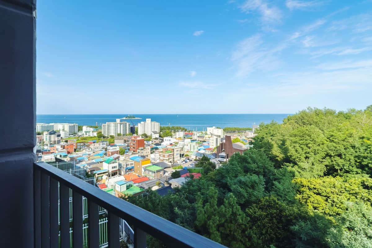 Un paisaje urbano con edificios, cielo despejado y vista al mar.