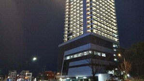 Ein Hochhaus mit mehreren Stockwerken, beleuchteten Fenstern und modernem architektonischen Design.