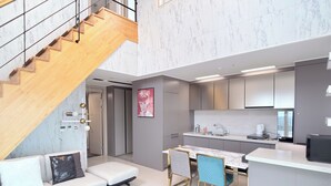 Ein modernes Apartment mit Treppe, Wohnbereich, Küche und Essbereich.