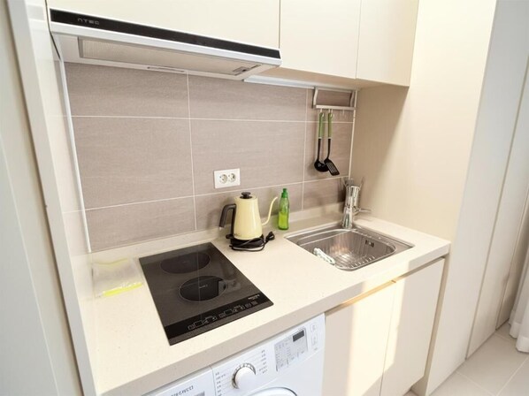A compact kitchen with a built-in stove, a dishwasher, and a sink.
