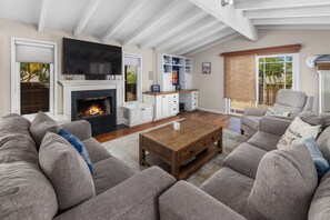 Ein Wohnzimmer mit Kamin, Fernseher und einer Couch.