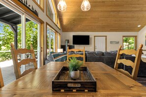 Ein Holzespeisesaal mit Stühlen, einem Blumentopf und einem Fernseher im Hintergrund.