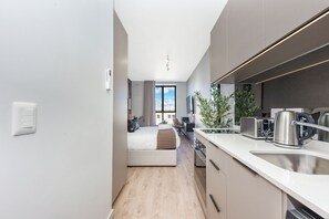 A modern kitchen with a built-in oven, a sink, and a toaster. - One Rosebank: Luxury Living (Johannesburg)