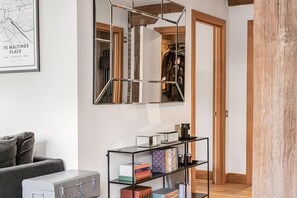 Ein Zimmer mit einer Karte, einem Bücherregal, einem Koffer und einem Spiegel.