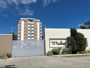 Una entrada con reja a un edificio residencial, con un cartel que dice 'Fontes de La Arboleda'.