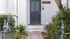 A house with a dark front door, a number '224' sign, and a brick pathway leading to the entrance. - Grand Victorian Stay in the Heart of Glebe (Glebe)