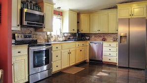 A kitchen with a stainless steel refrigerator, oven, microwave, and dishwasher. - Lake Seminole Retreat with Boat Slip (Sneads)