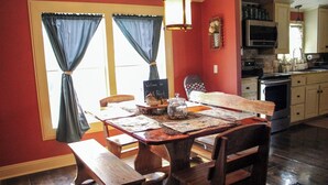 A dining area with a wooden table, benches, and a chalkboard sign. - Lake Seminole Retreat with Boat Slip (Sneads)