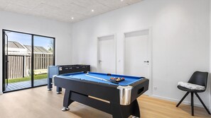 A pool table in a room with a door, a chair, and a view of the outside. - VillaVilla 977 - Hals, Nordjylland (Hals)