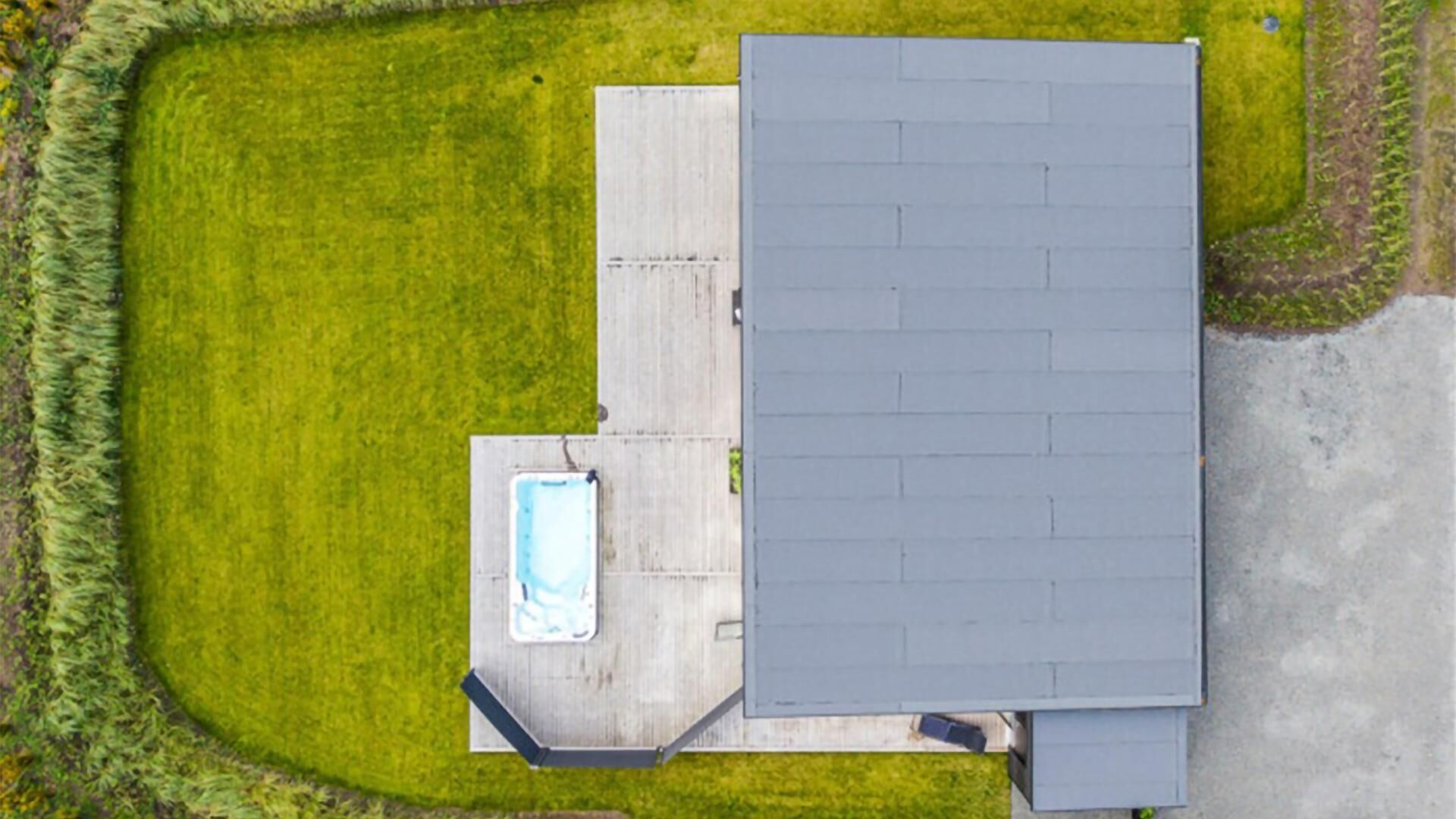 Vue aérienne d’une propriété comprenant un grand bâtiment, une piscine et une pelouse bien entretenue.