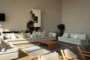 Ein modernes Wohnzimmer mit zwei Sofas, einem Couchtisch und einem Bücherregal.
