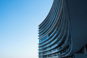 En moderne bygning med en buet facade og flere altaner.