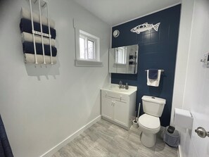 A bathroom with a toilet, sink, and towel rack.