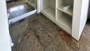 Een kamer met een kledingkast, een bed en uitzicht door een open deur.