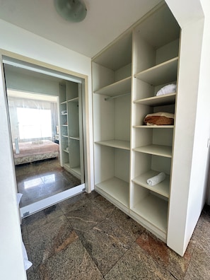 A room with a wardrobe, a bed, and a view through an open door. - Apartment for 5 People - Oceanfront (Fortaleza)
