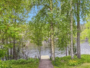 A wooden pathway leading to a lake surrounded by trees.