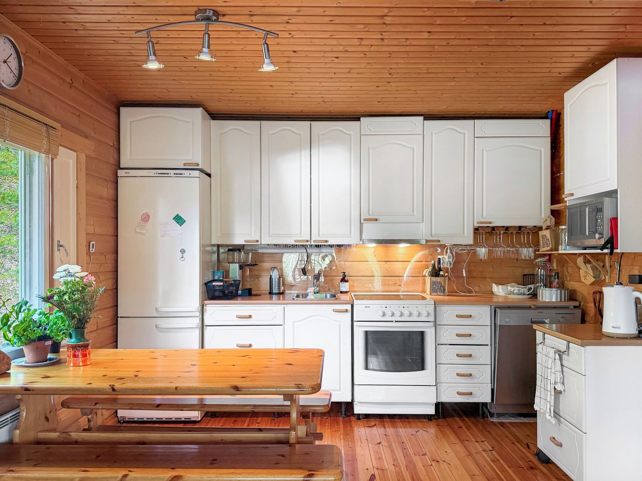 Une cuisine avec des meubles en bois, un réfrigérateur, une cuisinière et un four à micro-ondes.