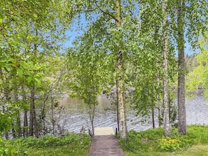 A wooden pathway leading to a lake surrounded by trees. - Villa kaidanjylhä by Interhome (Puumala)