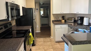 A modern kitchen with stainless steel appliances, a dishwasher, and a countertop with a knife block. - Charming condo in Downtown Gilbert (Gilbert)
