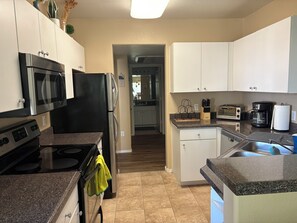 A modern kitchen with stainless steel appliances, a dishwasher, and a countertop with a knife block.