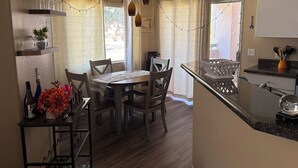 A kitchen with a dining table, chairs, a countertop, and a sink. - Charming condo in Downtown Gilbert (Gilbert)