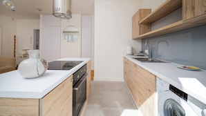 Eine moderne Küche mit Holzschränken, einem eingebauten Backofen und einem Geschirrspüler.