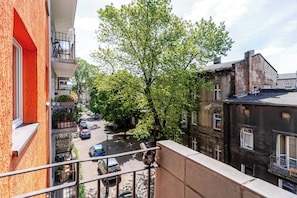 A street view with buildings, a tree, and parked cars.