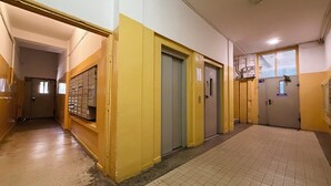Käytävä, jossa on kaappeja, ovia ja laatoitettu lattia.