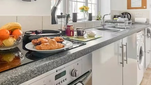 Une cuisine moderne équipée d’une cuisinière, d’un évier et offrant une vue sur l’extérieur.