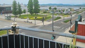 Un paisaje urbano con un frente marítimo, un edificio moderno y una intersección de calles.