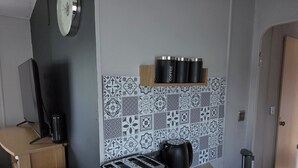 A kitchenette with a toaster, a kettle, and a coffee maker on the counter. - Seaside Haven Retreat in Skegness (Skegness)