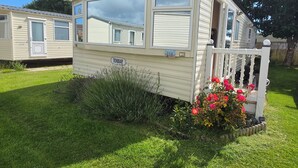 A mobile home with a porch, a window, and a door. - Seaside Haven Retreat in Skegness (Skegness)